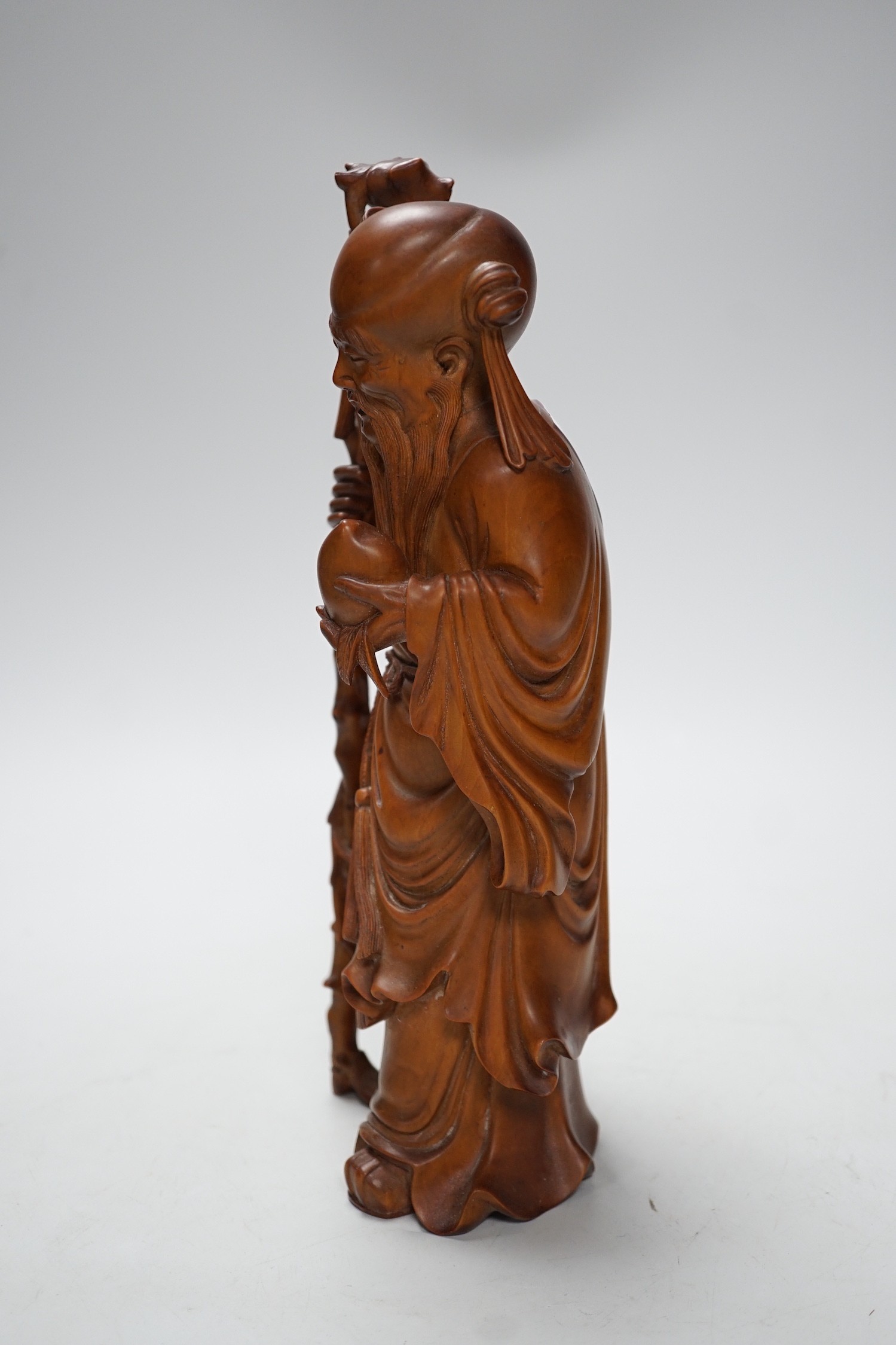 An early 20th century Chinese carved boxwood figure of Shou Lao, 26cm